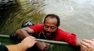 A Hurricane Katrina survivor is pulled from the flood water