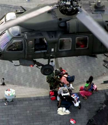 A National Guard Member prepares Hurricane Katrina survivors for an air rescue